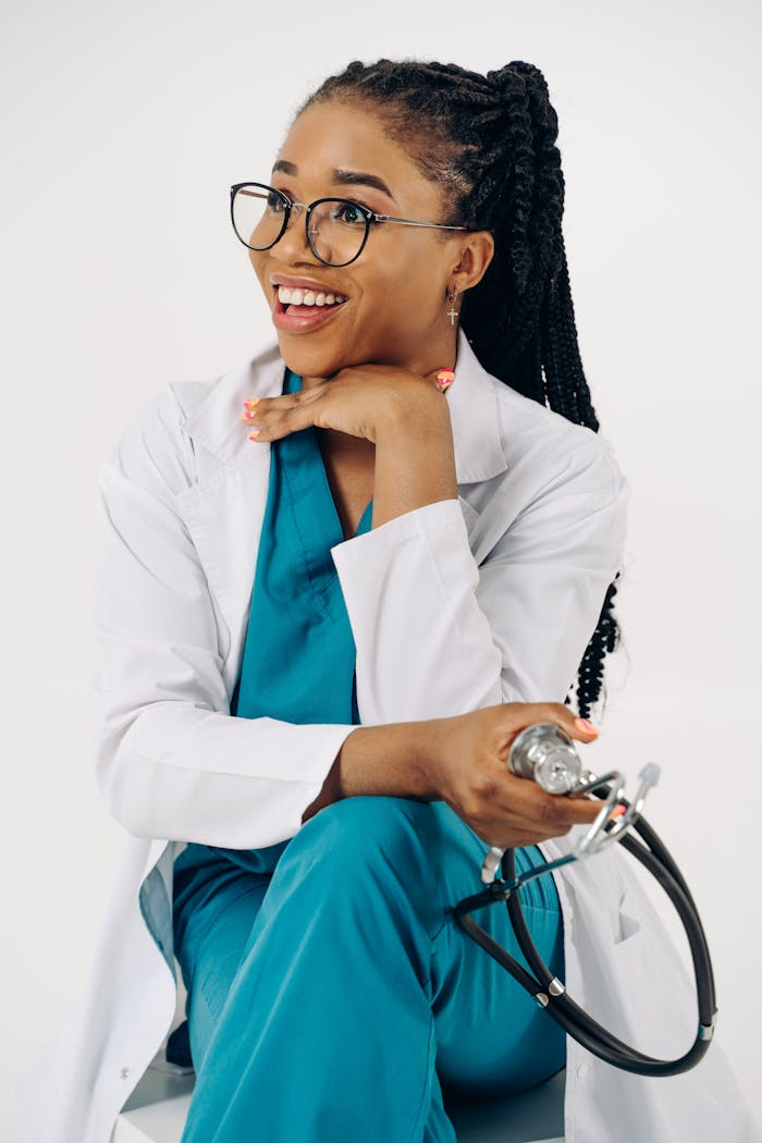 Young female doctor smiling in a lab coat, holding a stethoscope, conveying healthcare professionalism.